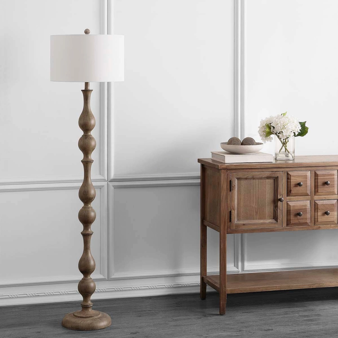 Tremblay wooden floor lamp styled with console table and decor, unlit three-quarter view showing light brown wood finish