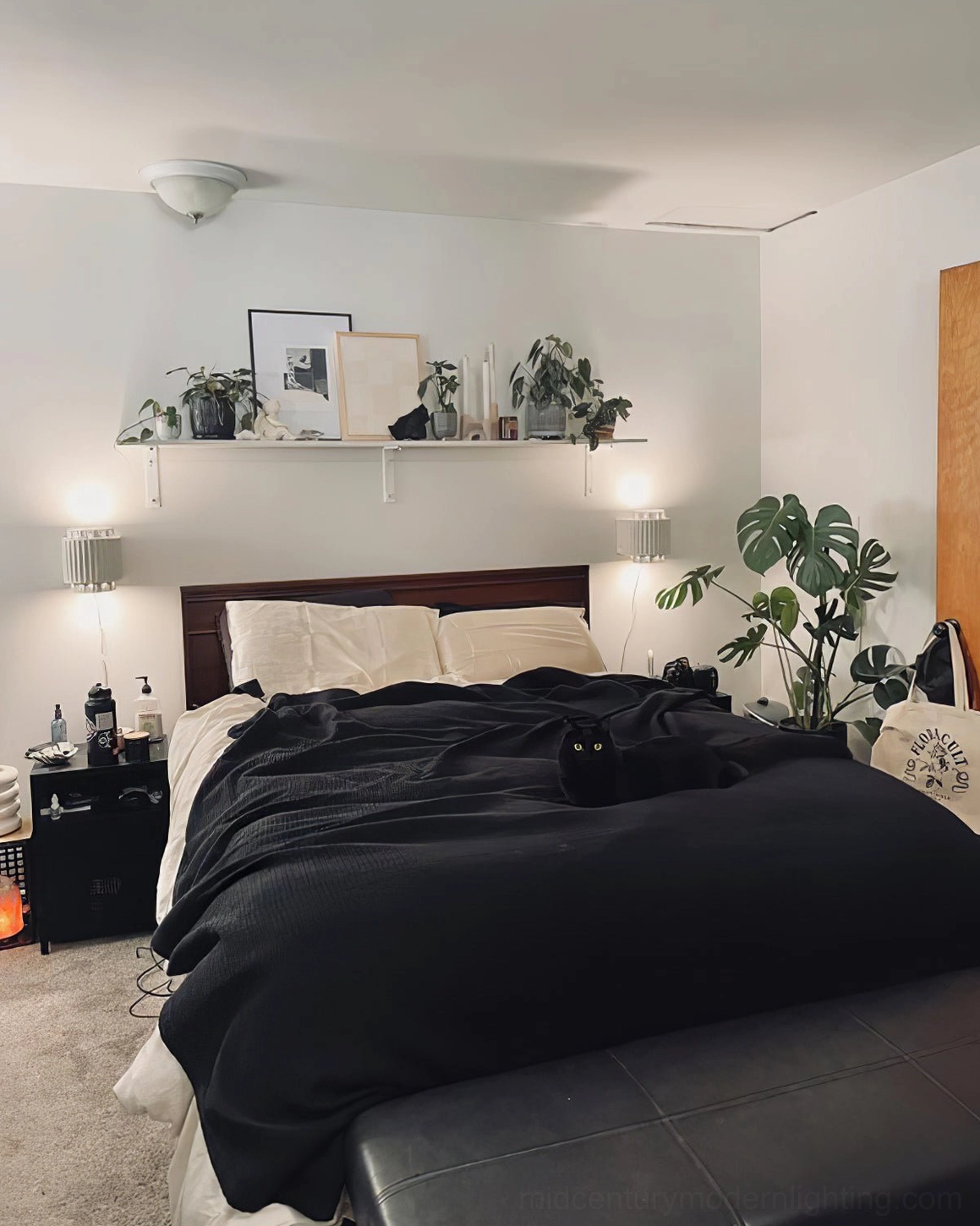 Paired Tristan wall sconces flanking both sides of bed in modern luxury master bedroom with floating shelves