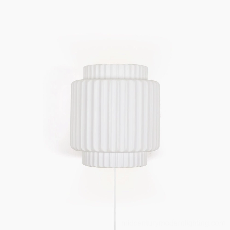 Tristan modern plug-in wall sconce with ribbed cylindrical design and matte white finish, front view on white background