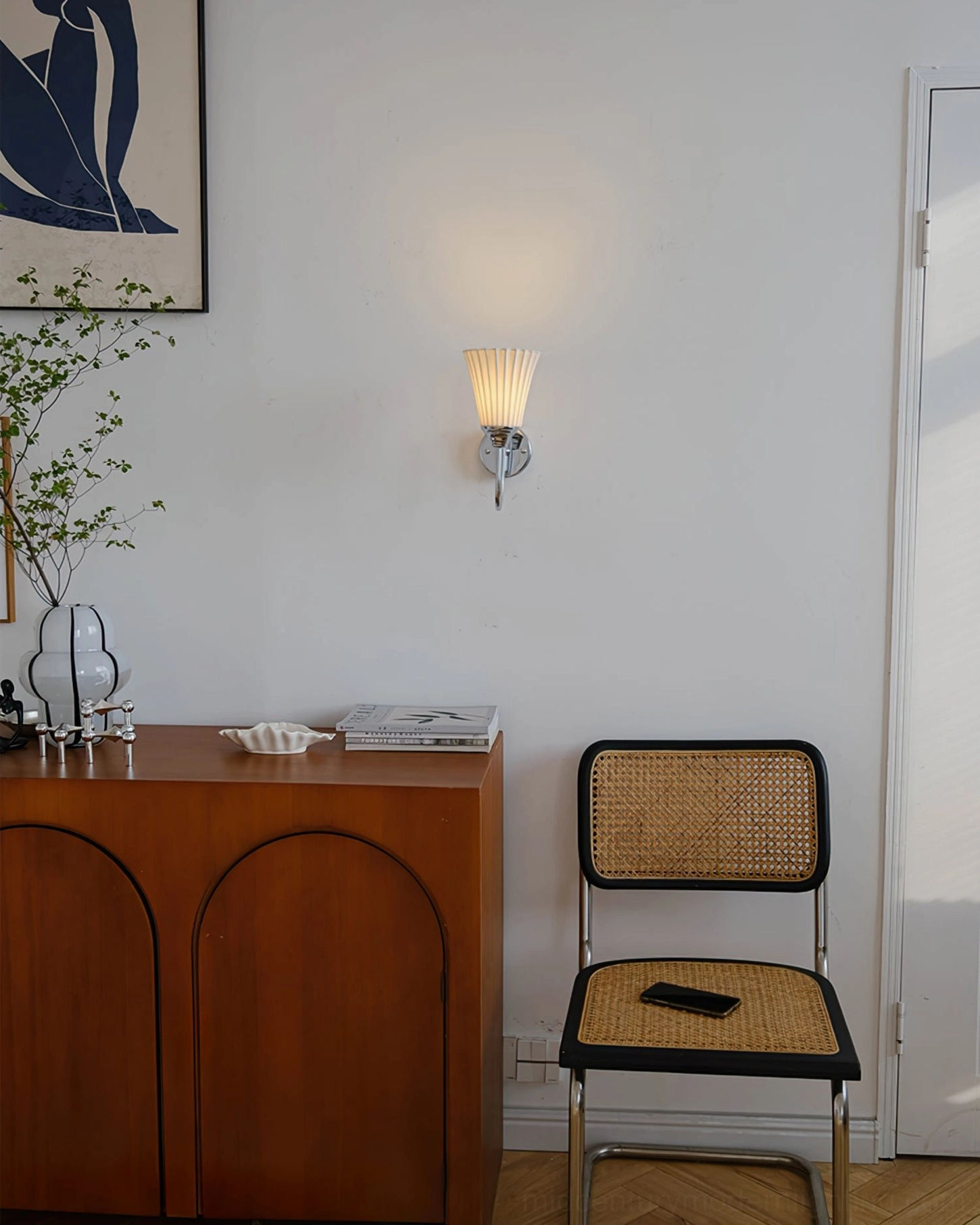 Trumpet wall sconce installed in boho vintage home corner with warm ambient lighting - full room view