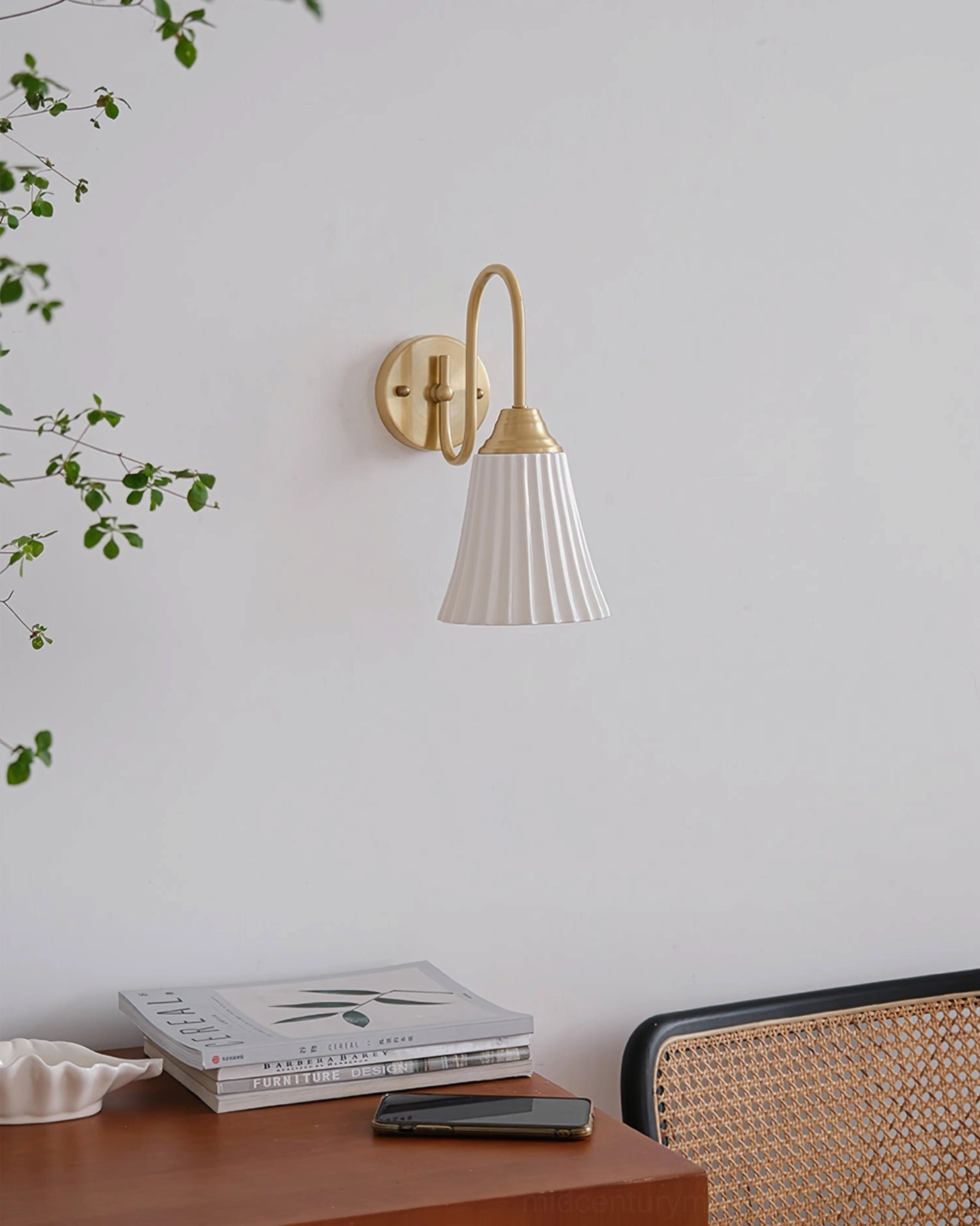 Brass gold ceramic wall sconce close-up showing pleated shade detail - side angle residential installation