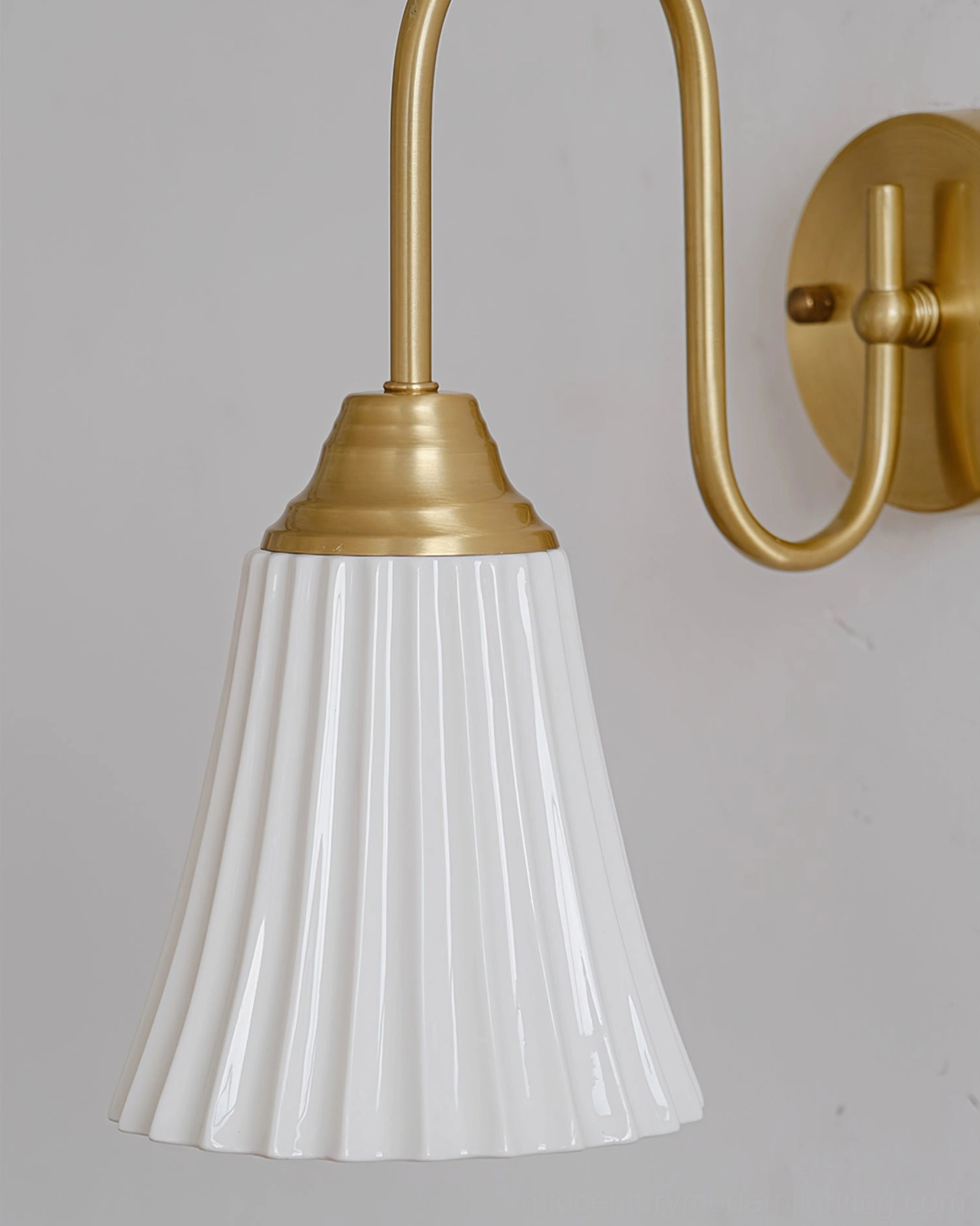 Brass gold ceramic wall sconce close-up frontal view - sculptural pleated shade architectural design