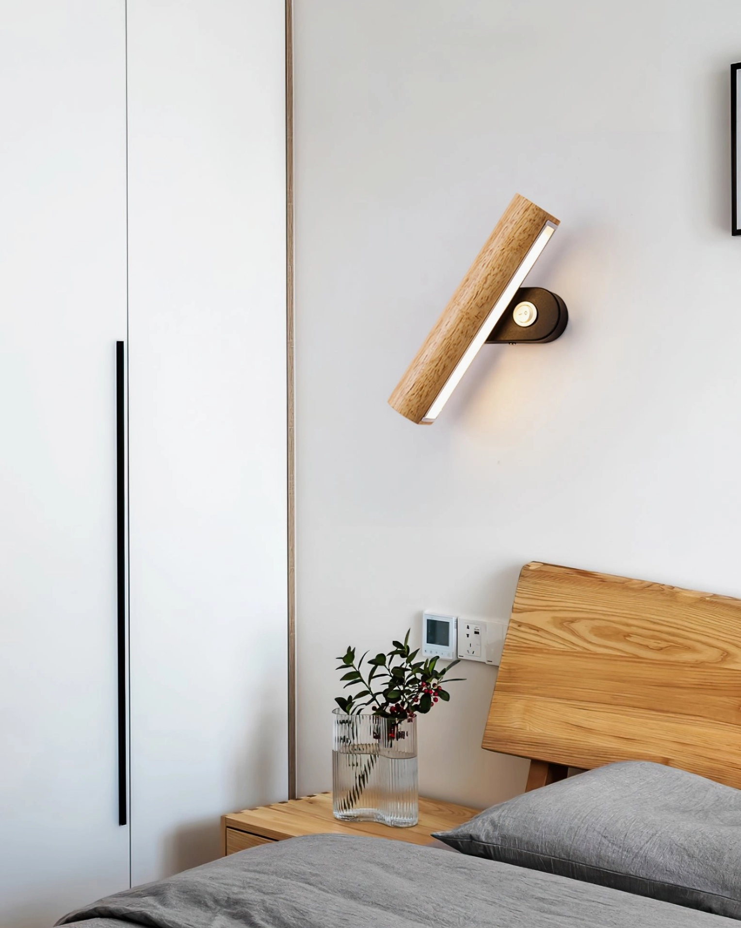 Rotatable tube wall lamp installed in Japanese-style bedroom beside bed, warm bedroom interior lighting setup
