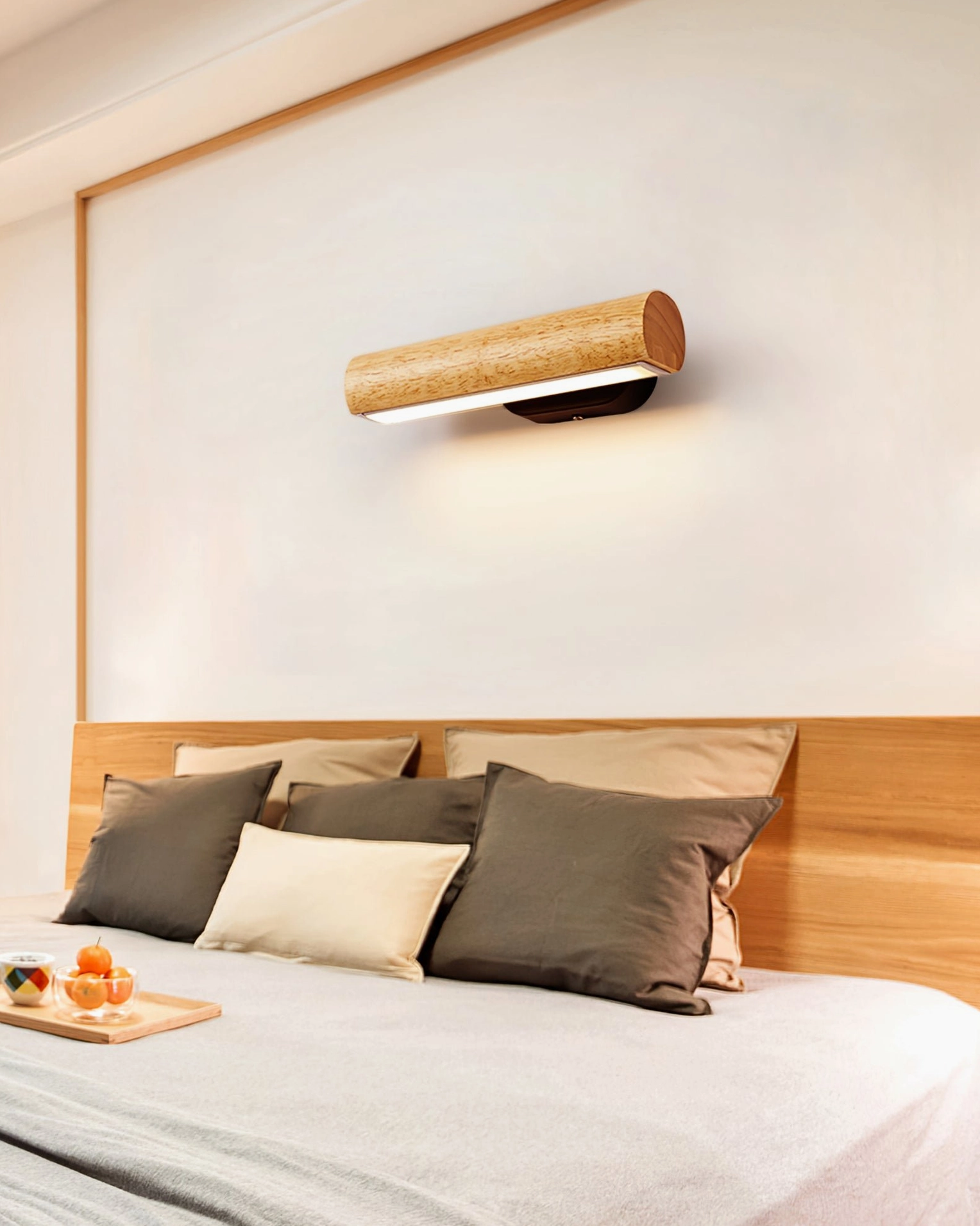 Mid-century modern rotatable tube lamp mounted above master bed headboard, warm contemporary bedroom lighting