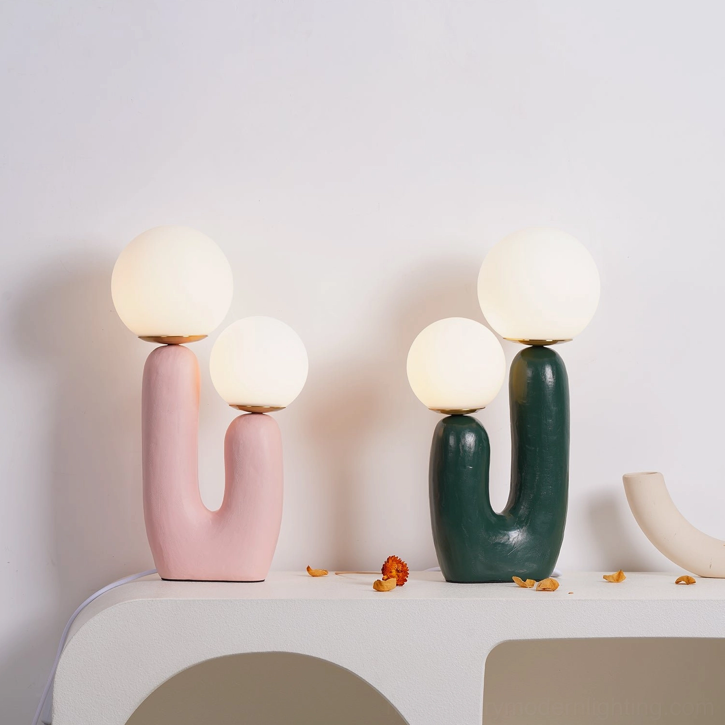 Two Oo ceramic table lamps illuminated in interior setting styled scene