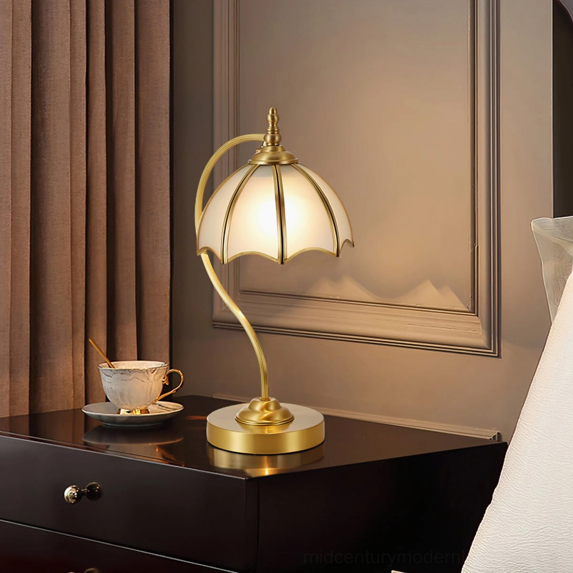 Umbrella table lamp providing warm ambient light on bedroom nightstand with wooden furniture