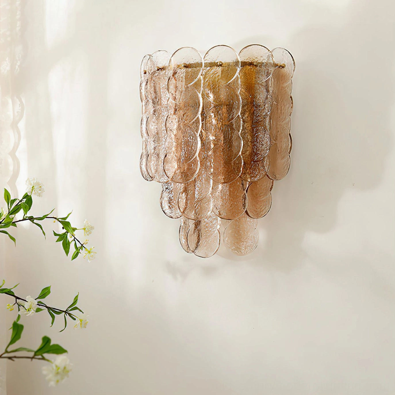 Unlit tiered amber glass wall lamp showing sculptural segmented form and warm finish