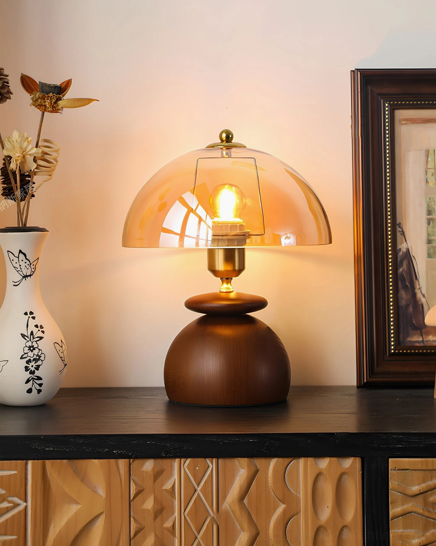 Valeska table lamp right side view with illuminated vintage filament bulb glowing through amber dome