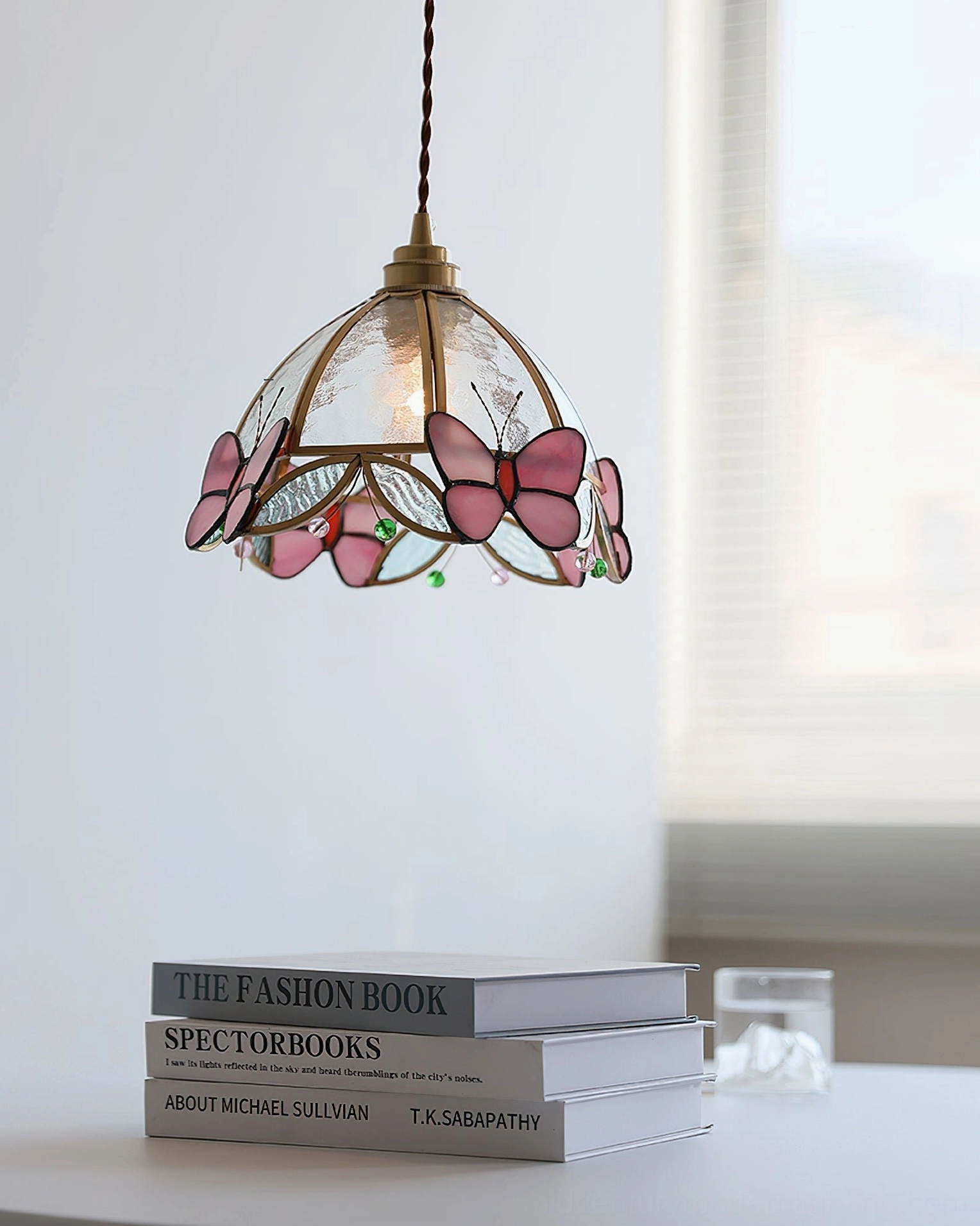 Overhead hanging view of Valinte stained glass butterfly pendant light with small butterfly details and bright indoor natural lighting