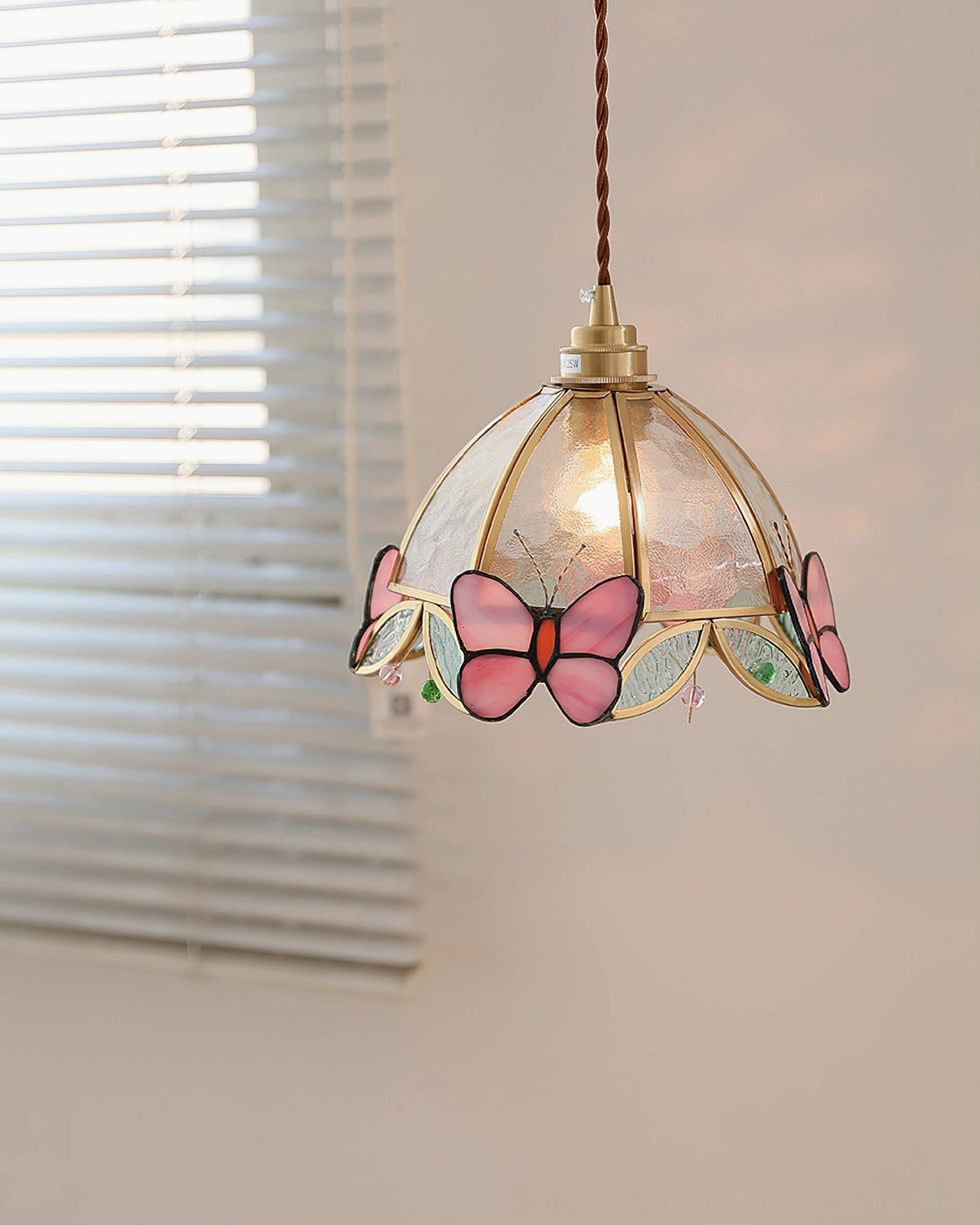 Side view of Valinte butterfly stained glass pendant lamp with natural daylight background and brass hanging hardware detail