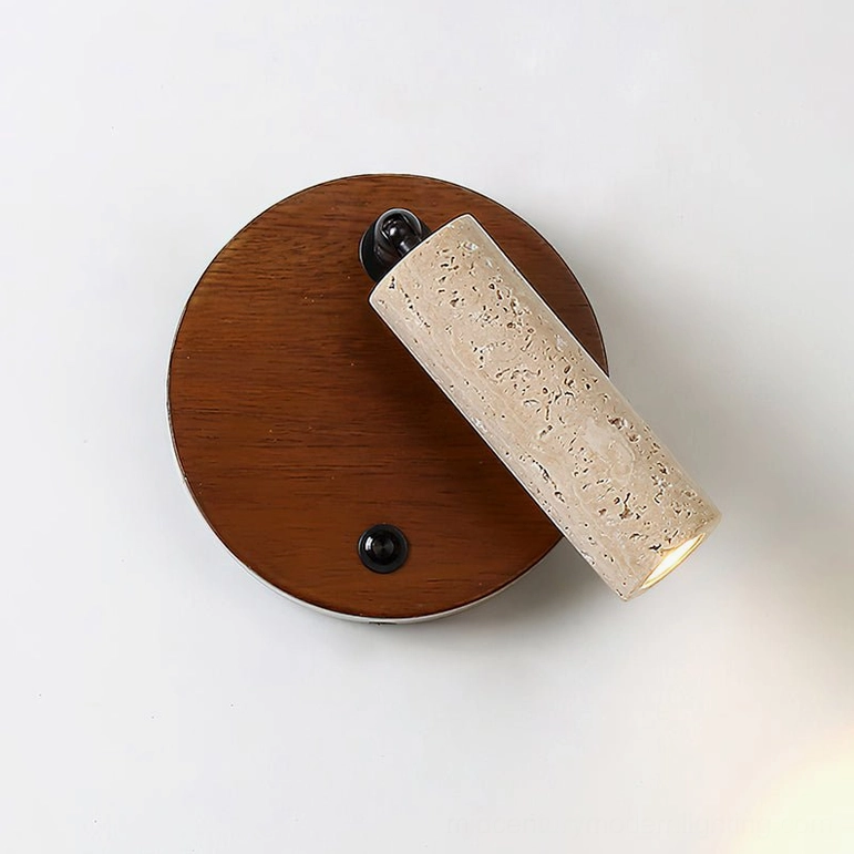 Veda travertine wall sconce close-up showing dark wood base with black mounting hardware