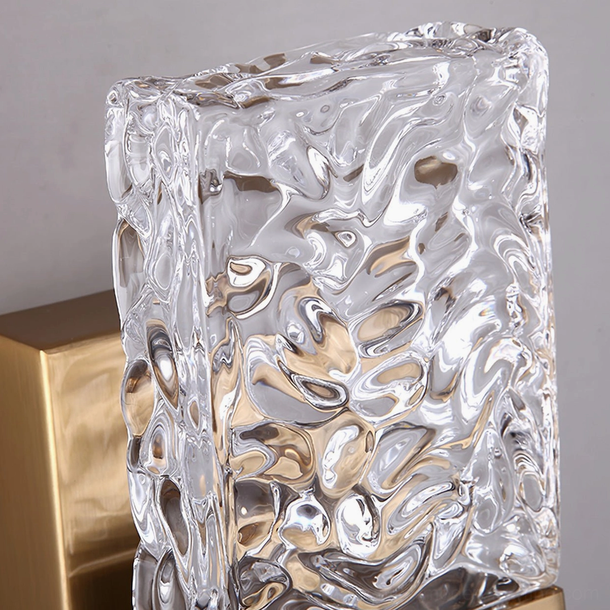 Vega brass gold wall sconce illuminated in modern living space, textured glass light diffusion