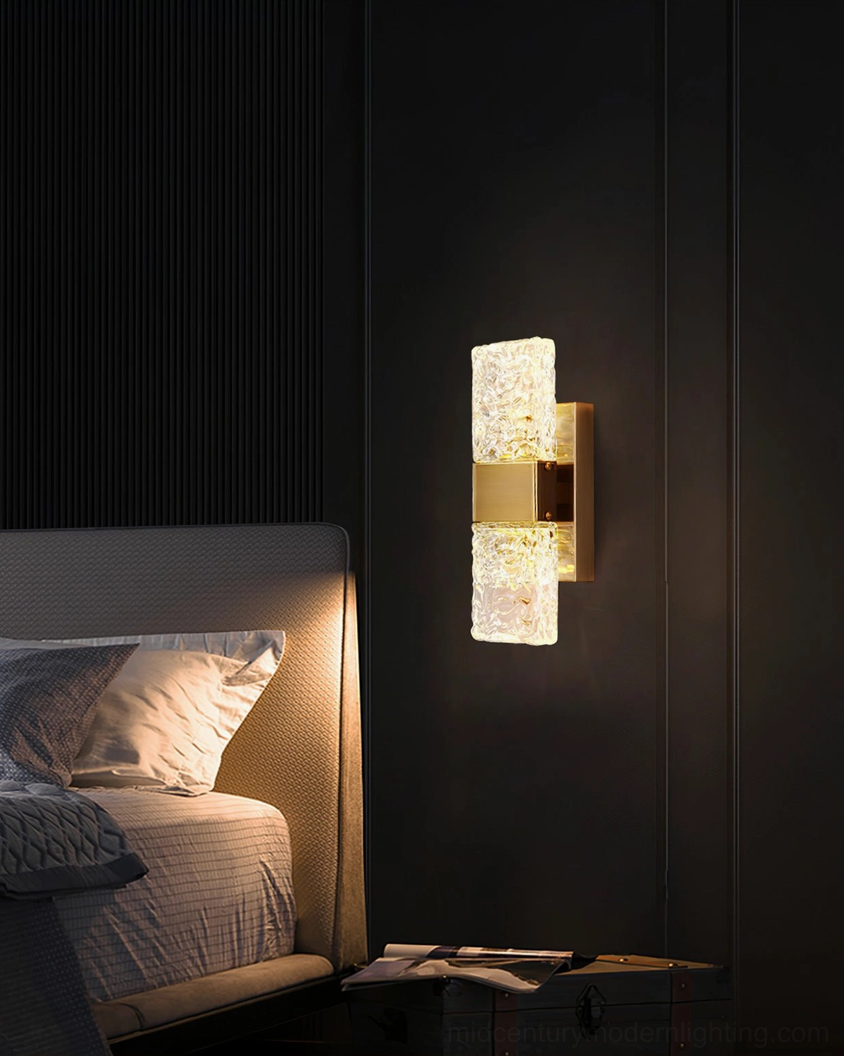 Single Vega wall lamp beside upholstered headboard emitting warm illumination in luxury bedroom