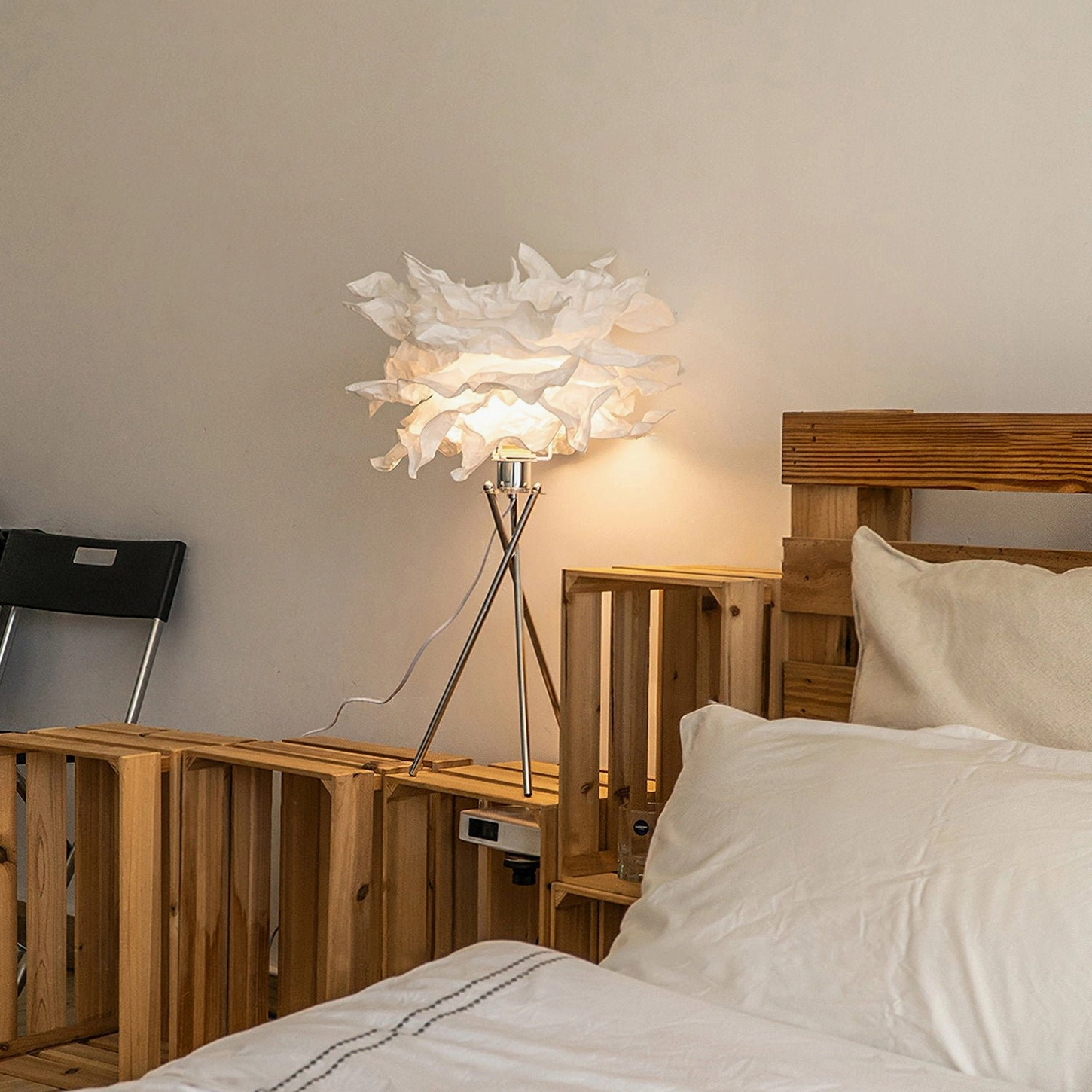 Veli handcrafted table lamp positioned beside wooden bed frame in master bedroom, demonstrating warm accent lighting in contemporary bedroom setting