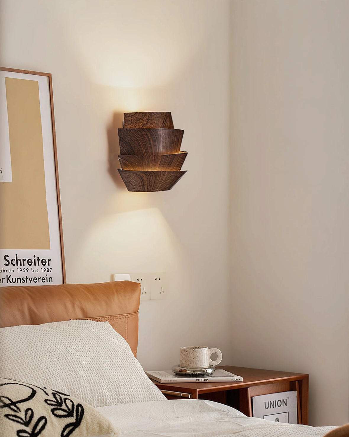 Veneer layered sconce in cozy bedroom corner with framed wall art leather headboard styling