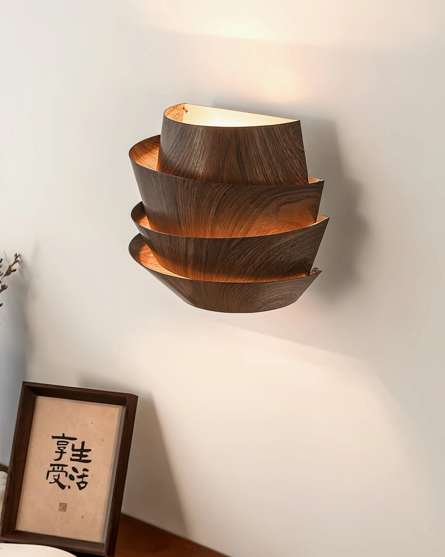Veneer sculptural wall lamp angled front view next to framed calligraphy artwork indoor styling