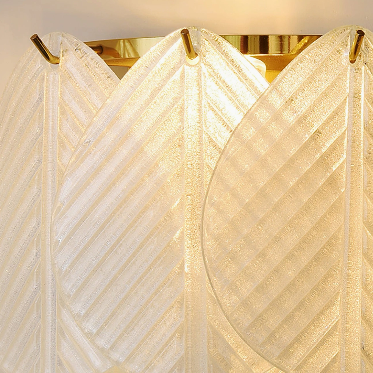 Close-up detail of Verbier wall lamp ribbed textured frosted glass brass gold mounting clips