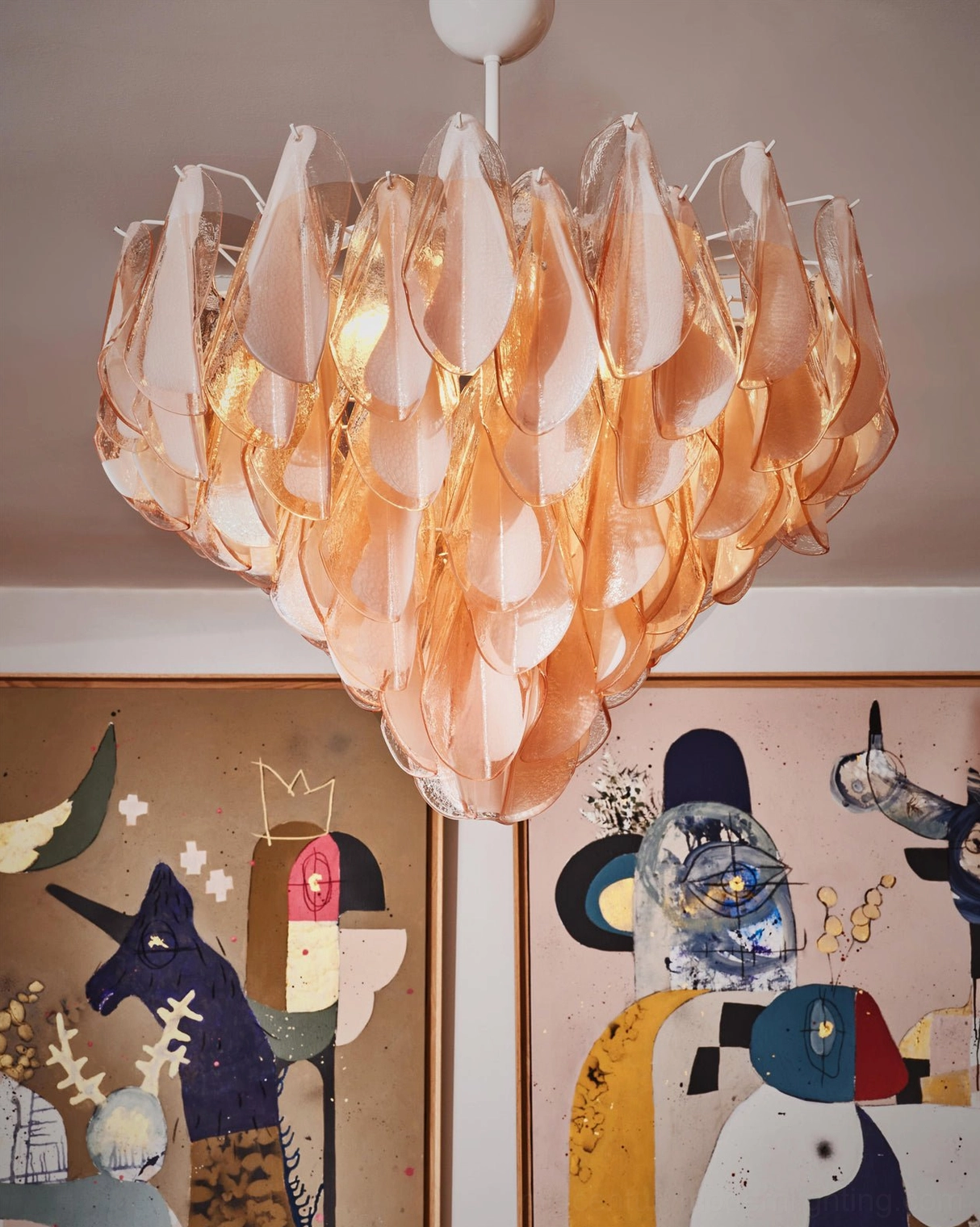 Illuminated amber-toned Murano glass chandelier petal design overhead view, glowing warm light casting soft ambiance