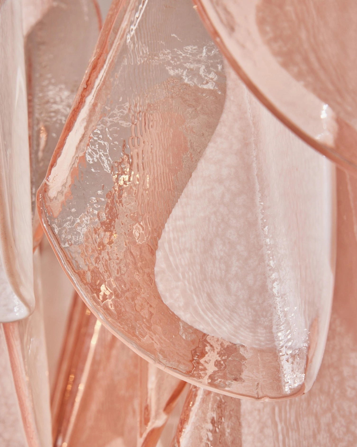Single curved pink glass petal with wavy edge, translucent Murano-style glasswork detail macro view