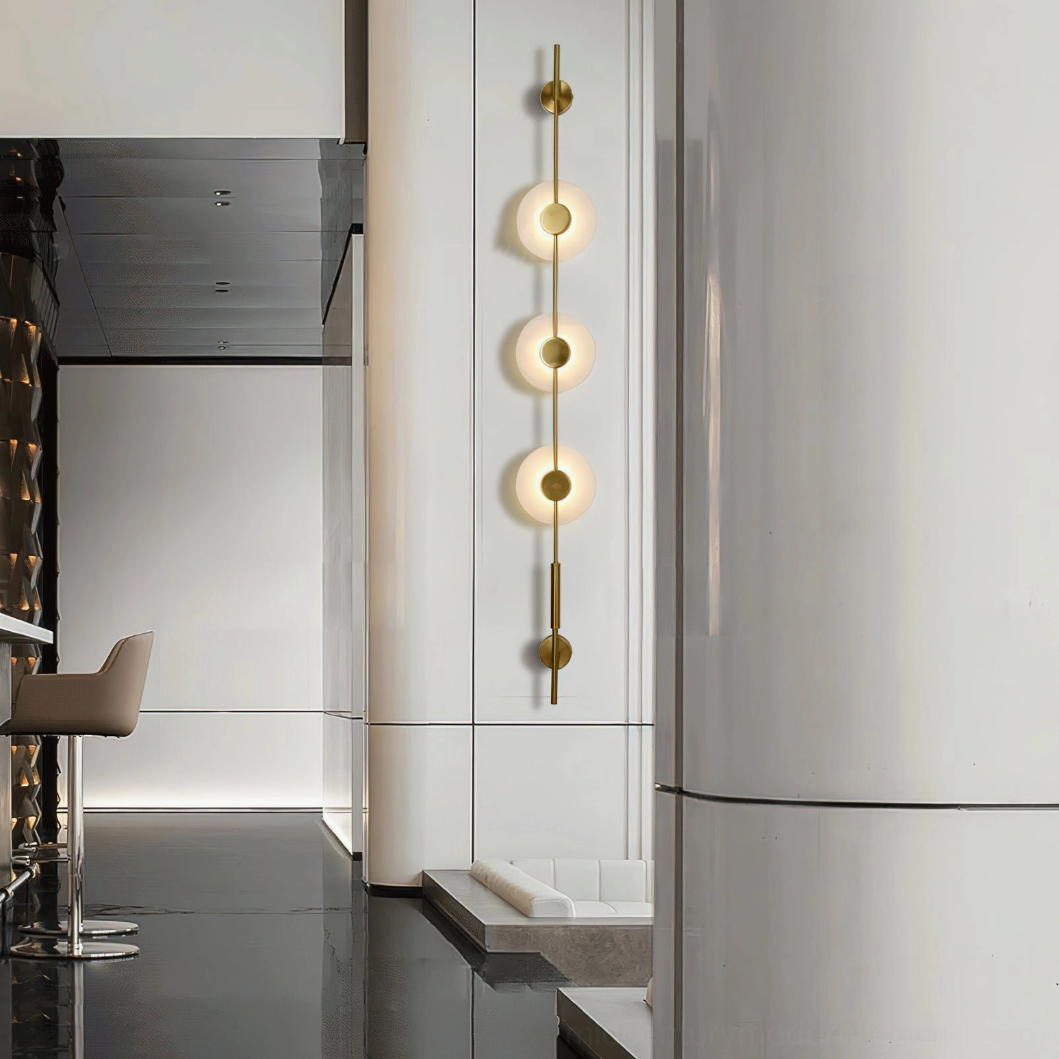 Three-light vertical alabaster wall lamp in luxury minimalist commercial corridor with brass gold finish and frosted alabaster covers