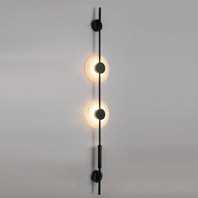 Close-up studio shot of matte black vertical alabaster wall lamp showing linear rod structure and two illuminated frosted light covers