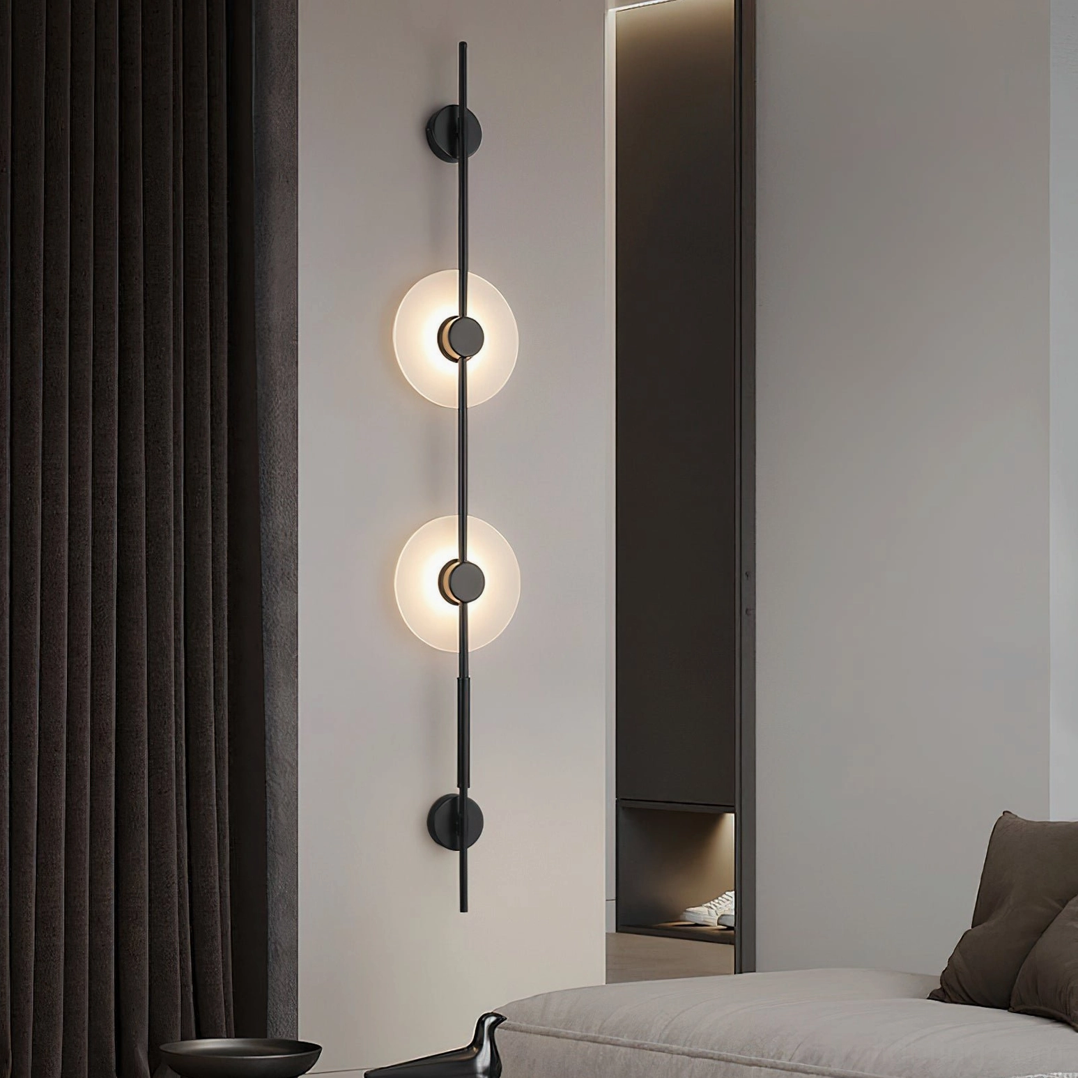 Black matte vertical alabaster wall lamp with two illuminated frosted glass discs installed in modern living room accent wall