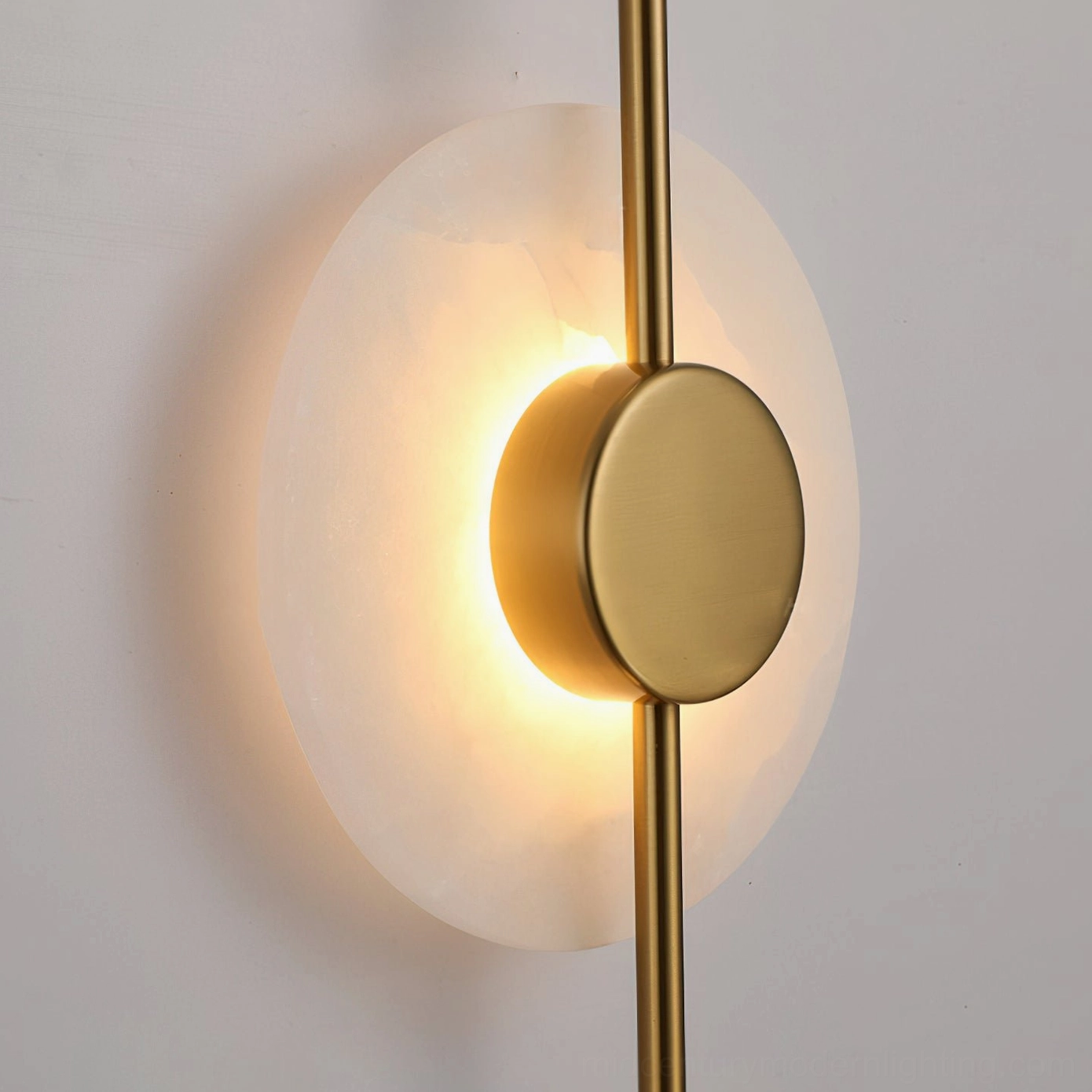 Installation view of vertical alabaster wall lamp in modern residential space above accent wall with warm glowing alabaster discs