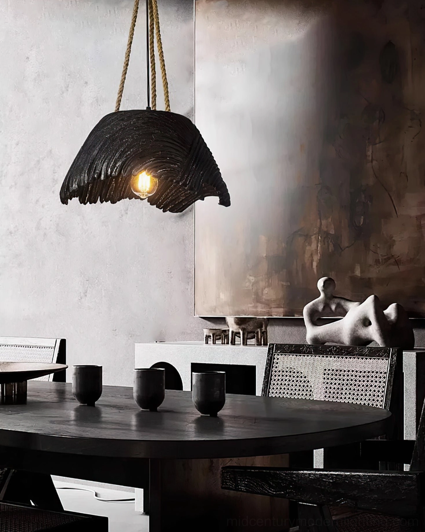 Handcrafted pendant light suspended in contemporary minimalist dining space with decorative accents