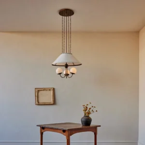 Brass pendant chandelier with globe shades installed in minimalist corner, mid-century modern style
