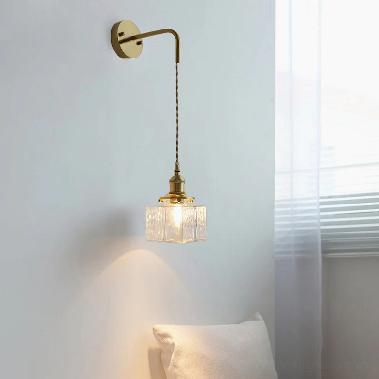 French vintage brass wall sconce with textured glass shade beside bedroom window