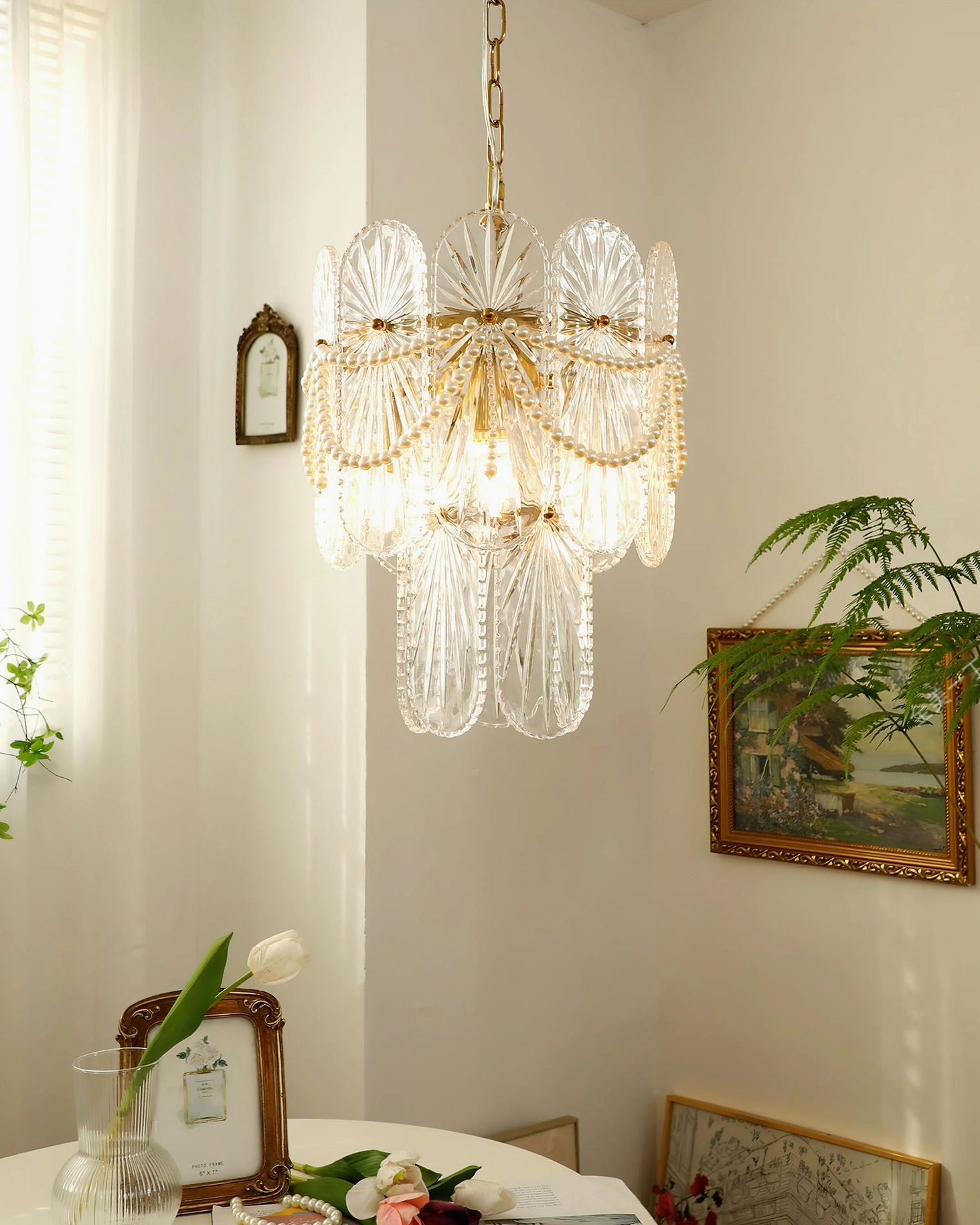 Two-tier vintage glass chandelier with gold finish and pearl beads creating elegant light diffusion