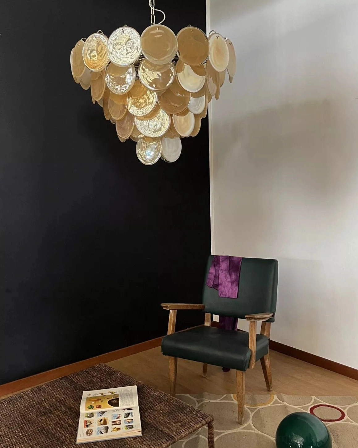 Distant front view of vintage yellow Murano disc chandelier creating warm ambient lighting in residential interior