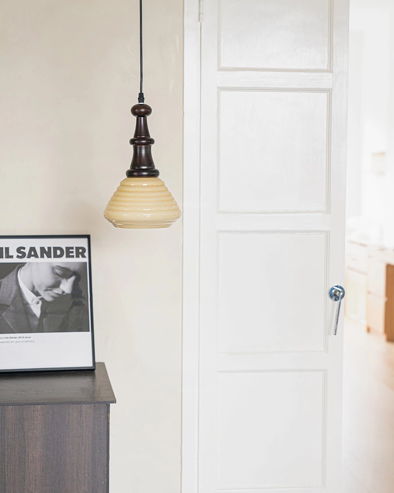 Vintage-inspired wooden pendant light with beige rippled glass shade and dark turned wood hardware on white studio background