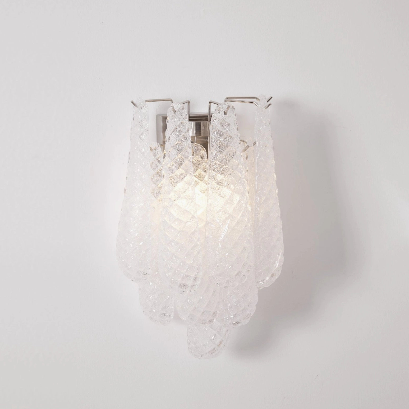 White frosted glass Viola Drop wall sconce fully illuminated on white studio background