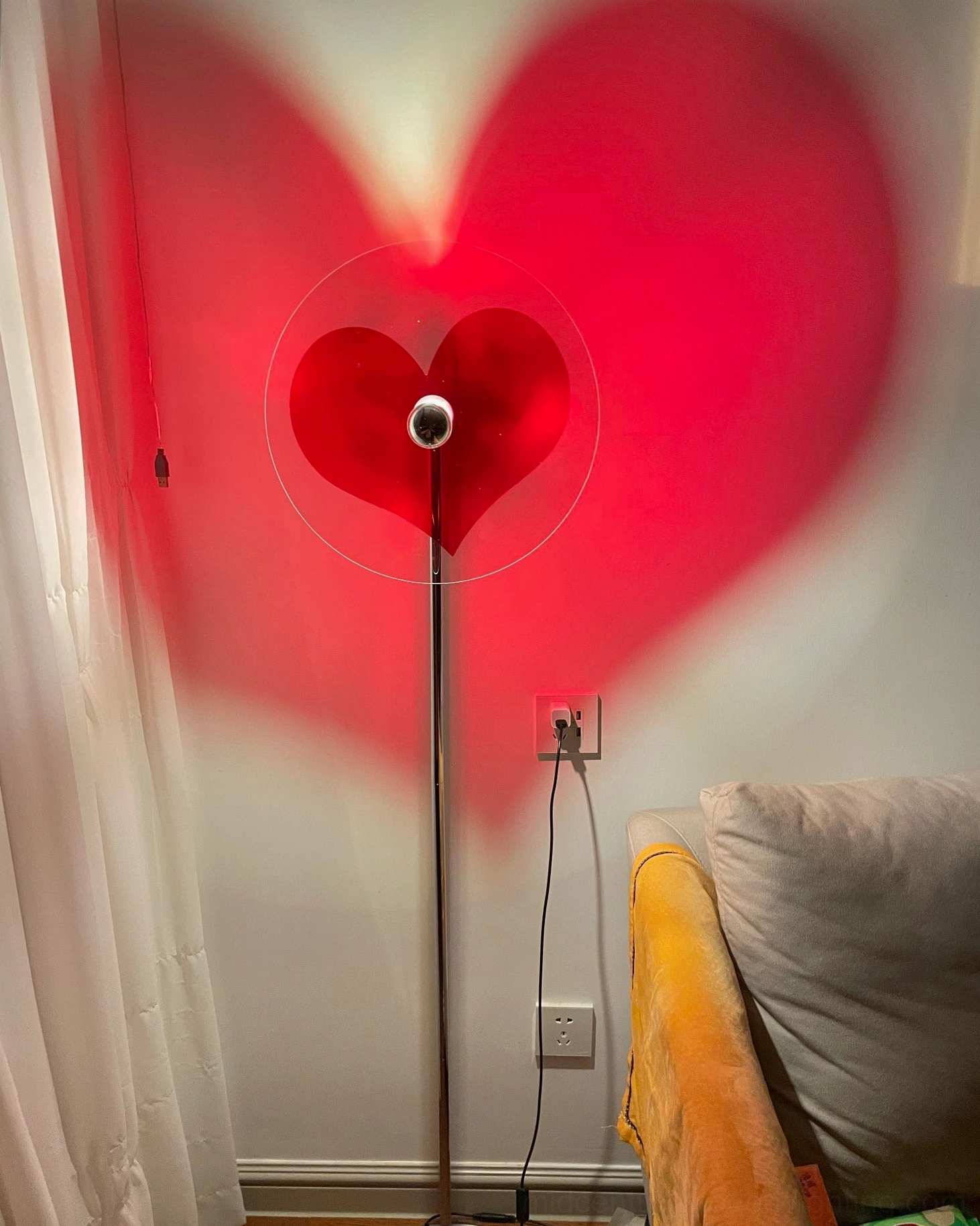 Modern heart floor lamp creating visually striking shadow projection for interior spaces
