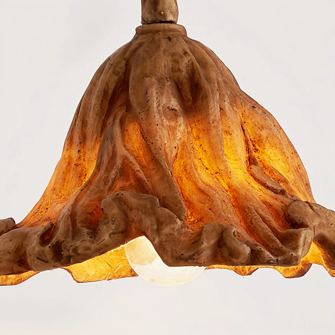 Volcano lampshade bottom view showcasing exposed warm bulb and intricate ruffled textured brown surface