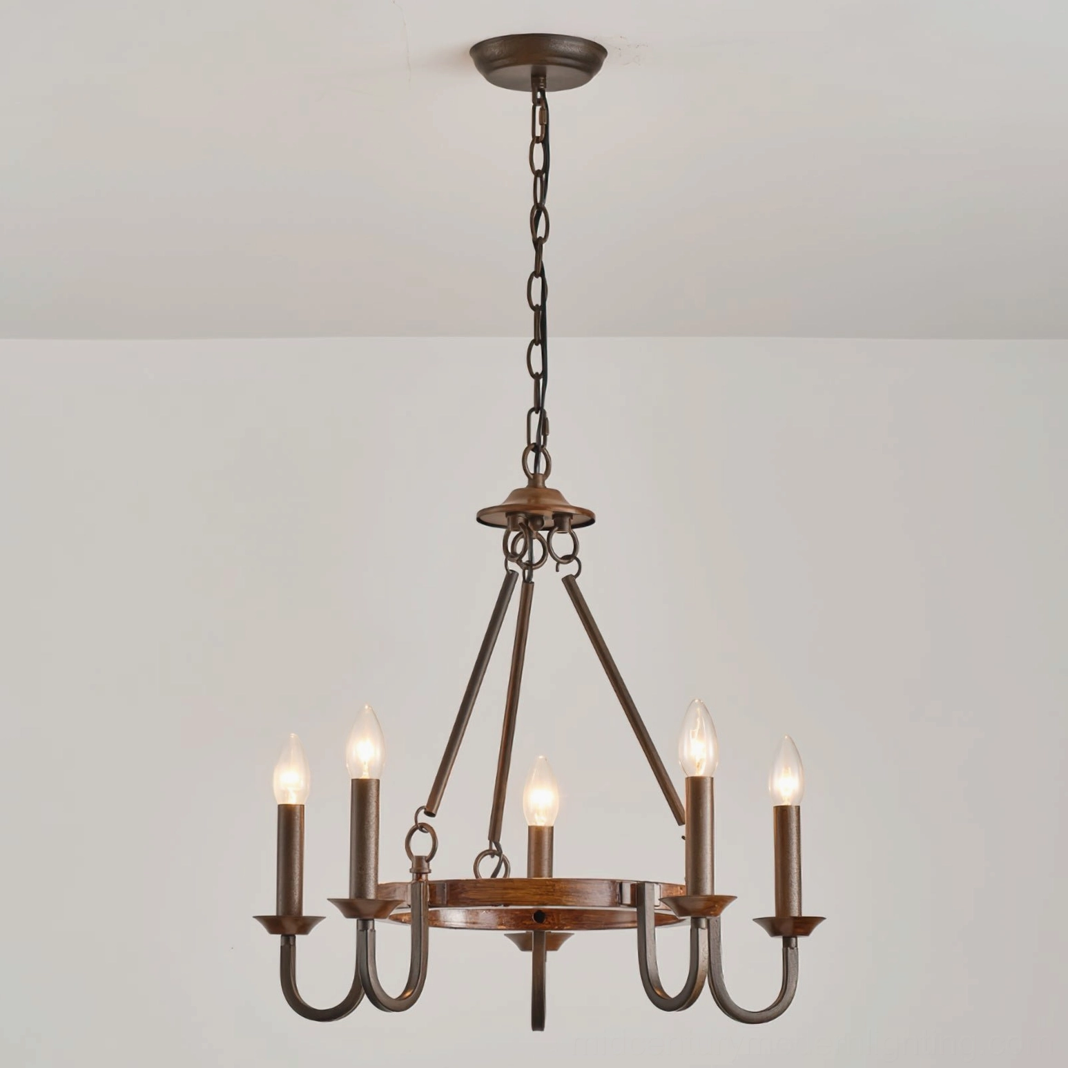 Rustic wagon wheel chandelier with vintage candle bulbs front eye-level studio view