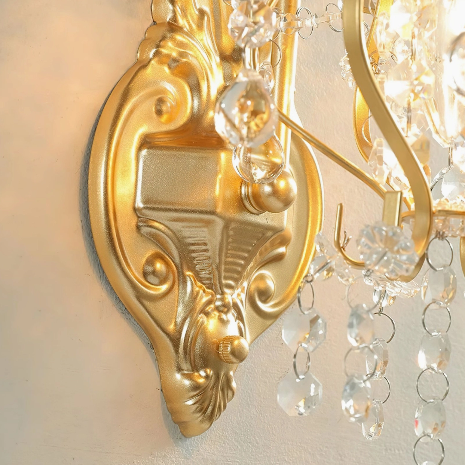 Macro photography of wall lamp base mounting hardware showing carved gold decorative ornamental details