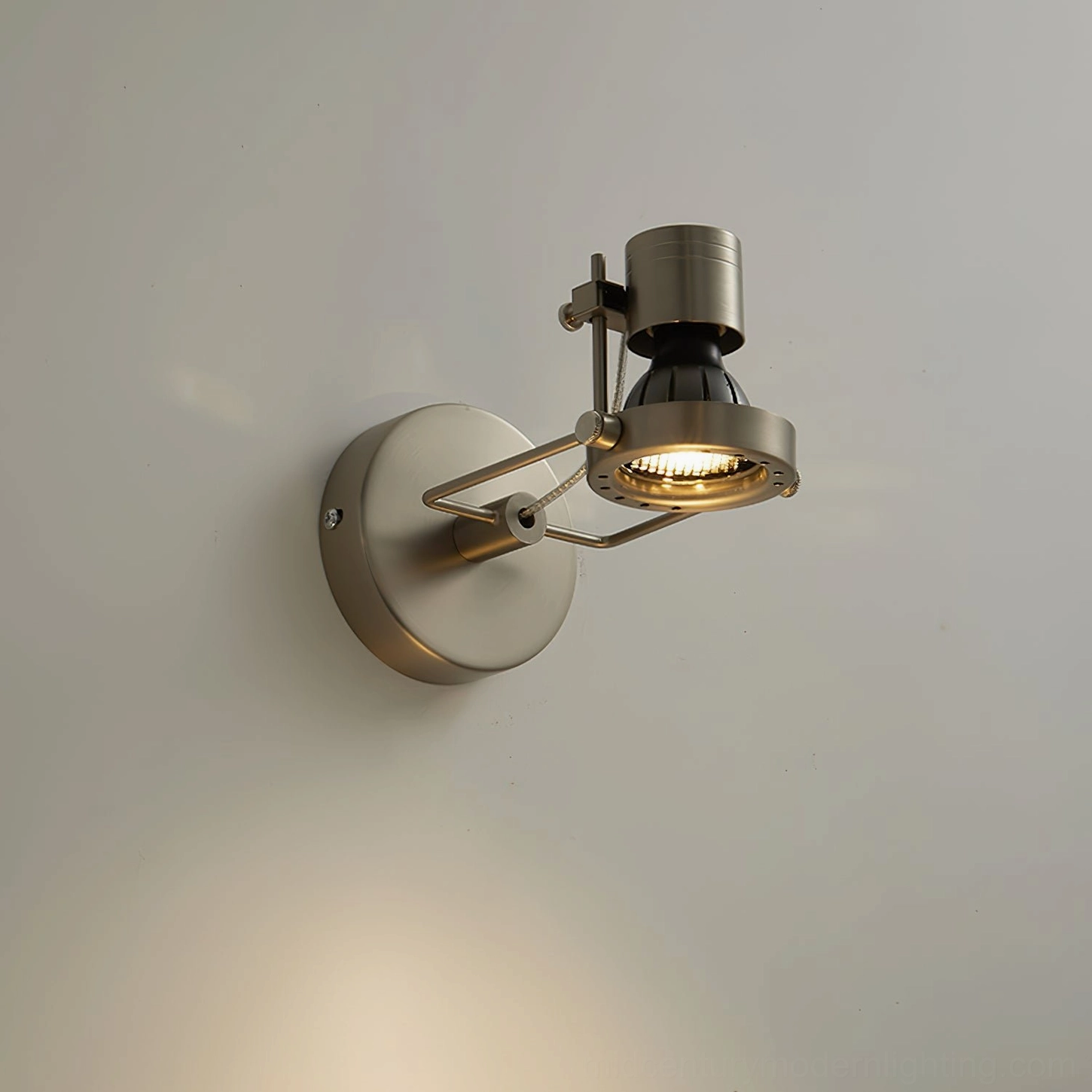 Low-angle side view of wall-mounted spotlight with warm light emission and minimalist brushed metal design