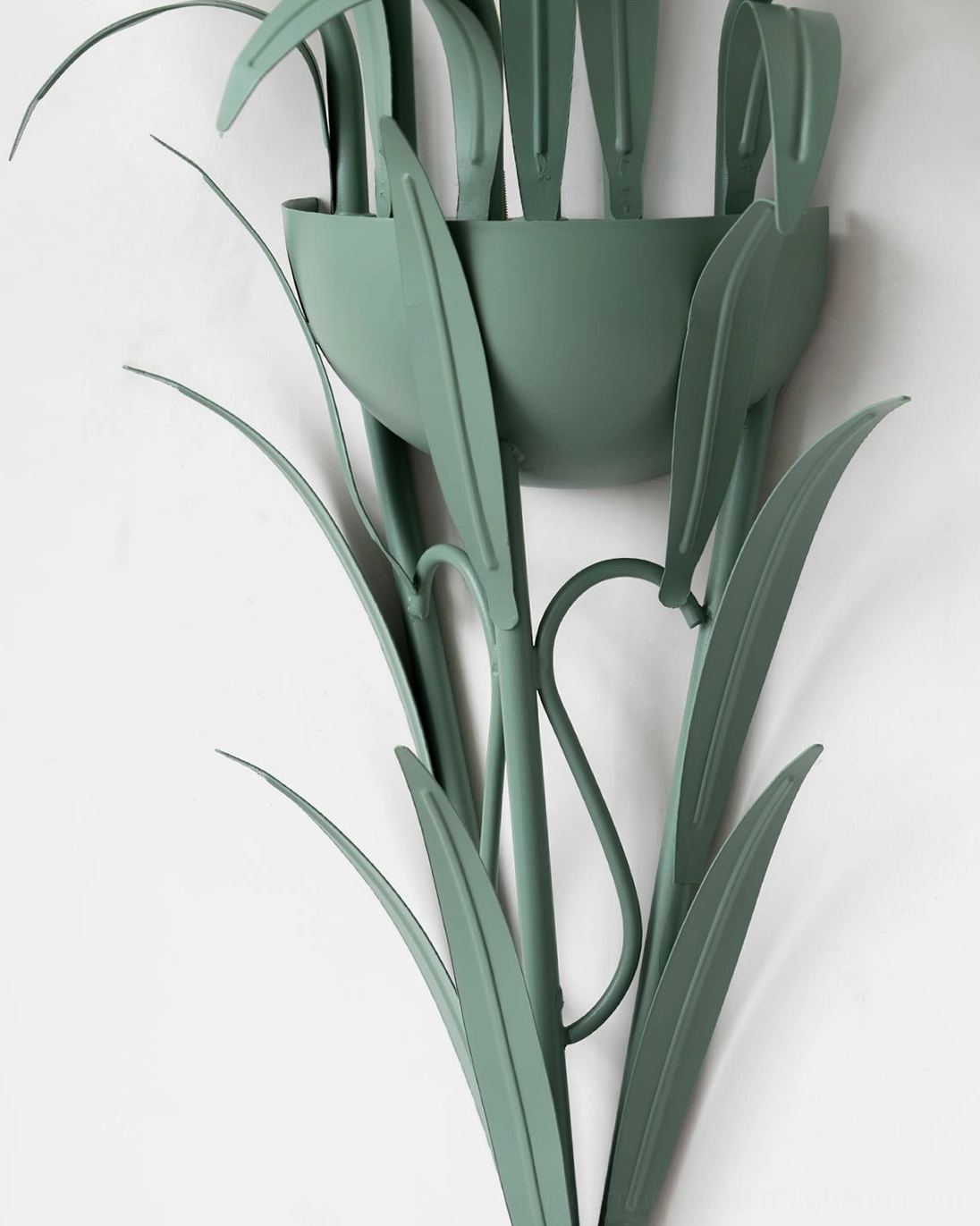 Close-up detail of matte green wrought iron floral frame, architectural botanical design