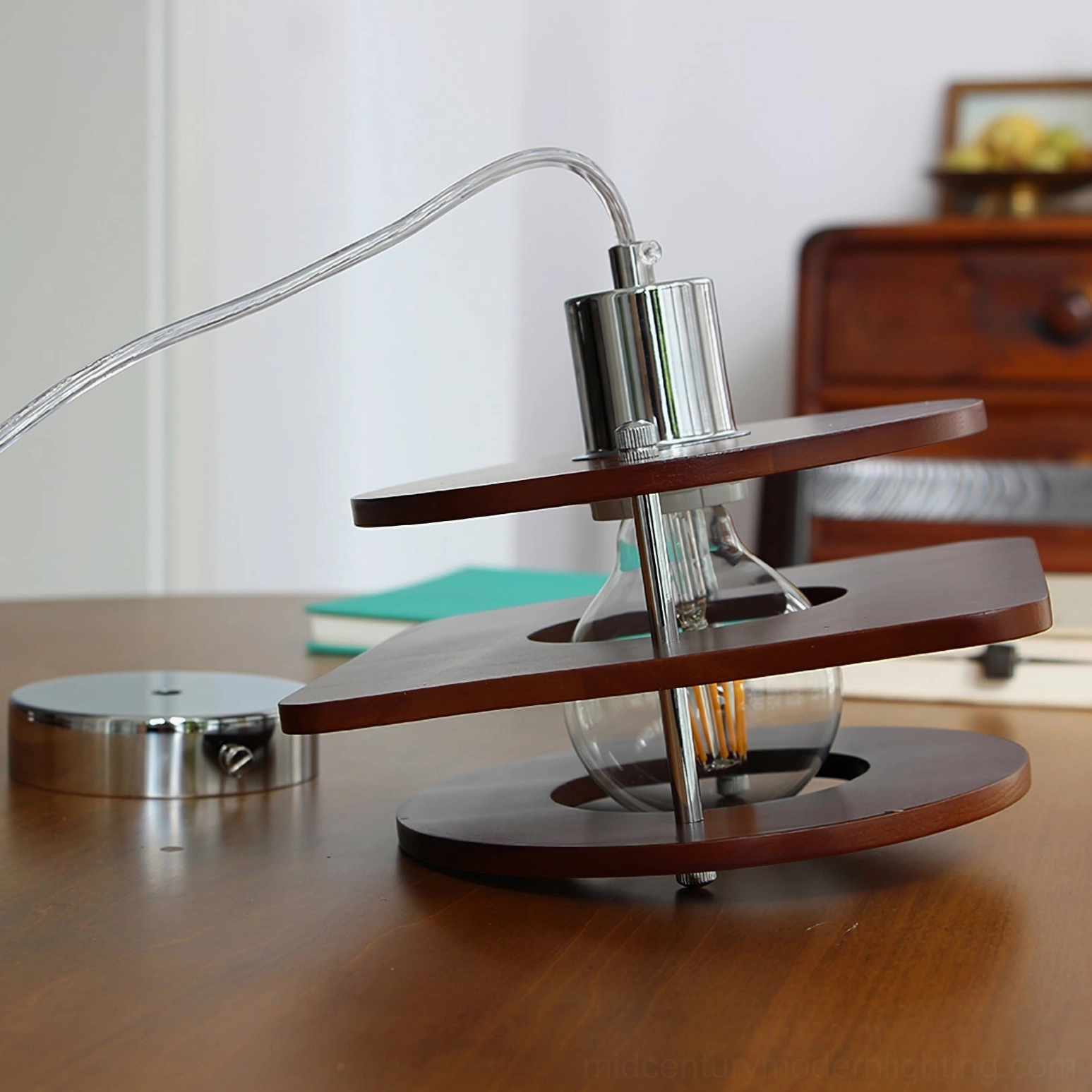 Mid-century modern walnut pendant lamp side angle, chrome canopy and flexible suspension cord detail