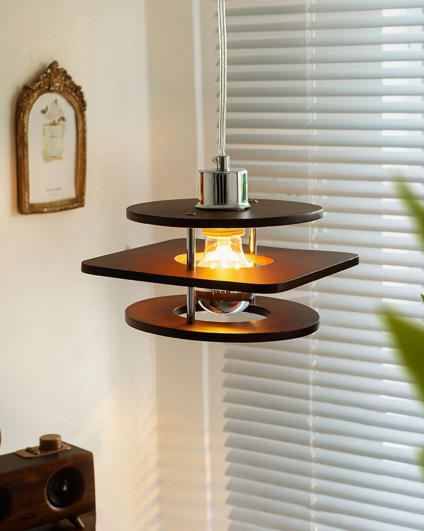 Retro walnut pendant lamp with tiered wood shades, chrome suspension rod, warm glowing bulb interior view