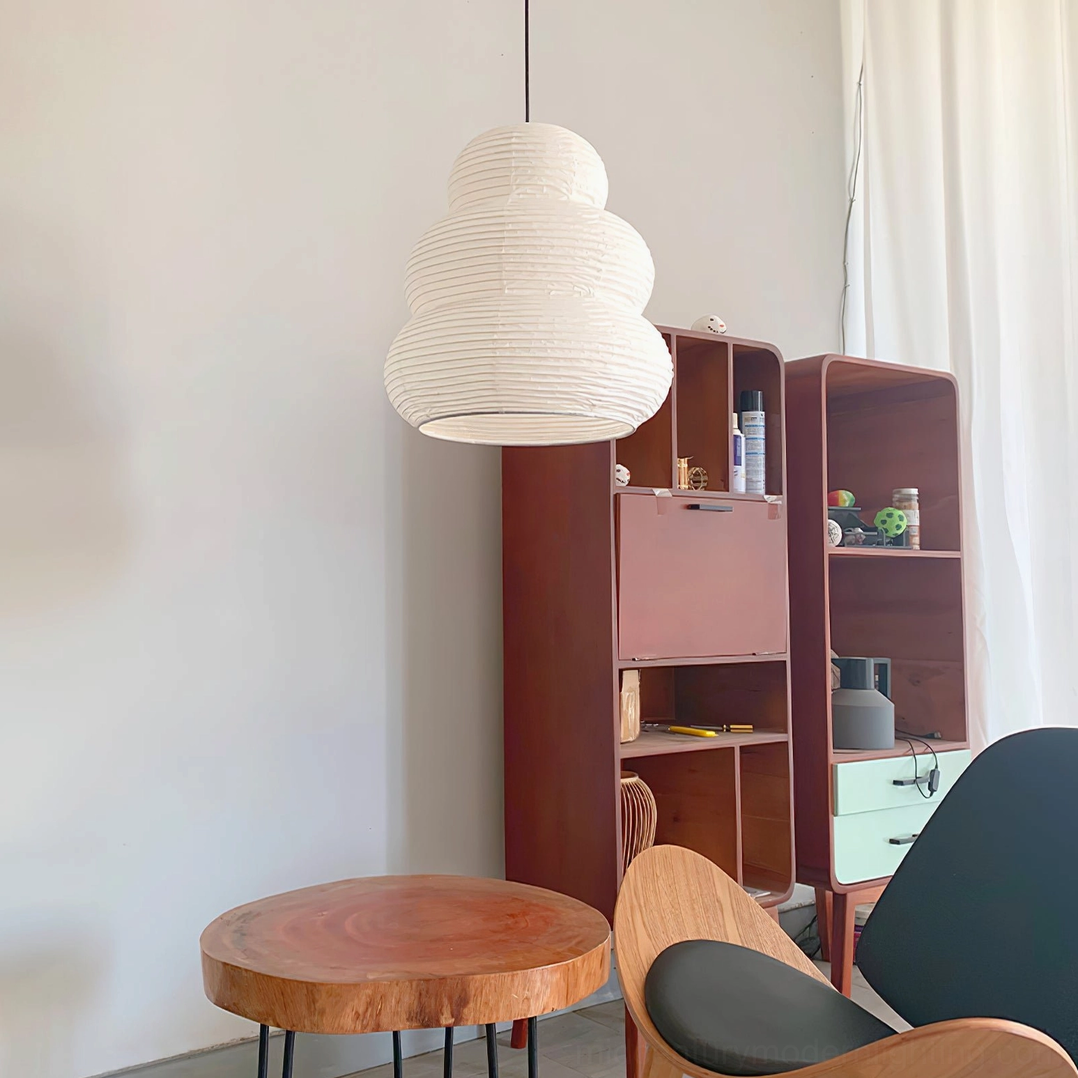 Washi 24N unlit pendant light in three-quarter view above mid-century wooden side table and cabinet