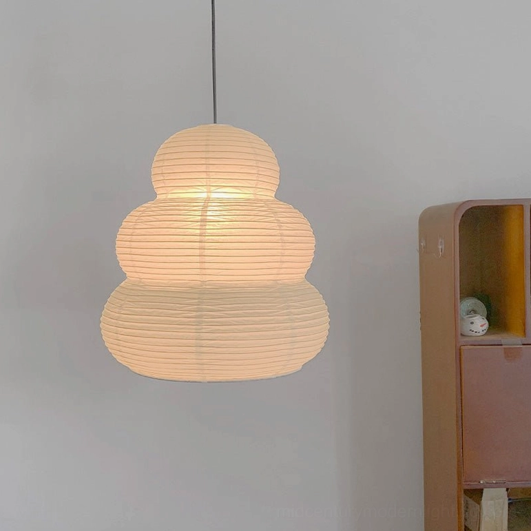 Washi 24N pendant light glowing warm beige against light gray wall, flat front view