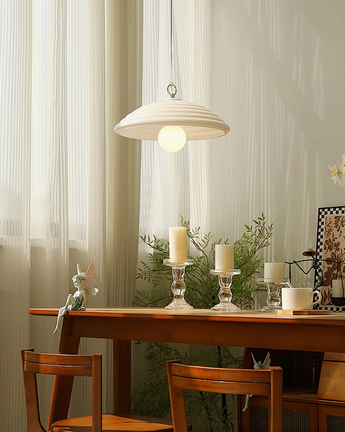 Wave pendant light with ribbed shade suspended above wooden dining table with warm neutral tones and decorative ornaments