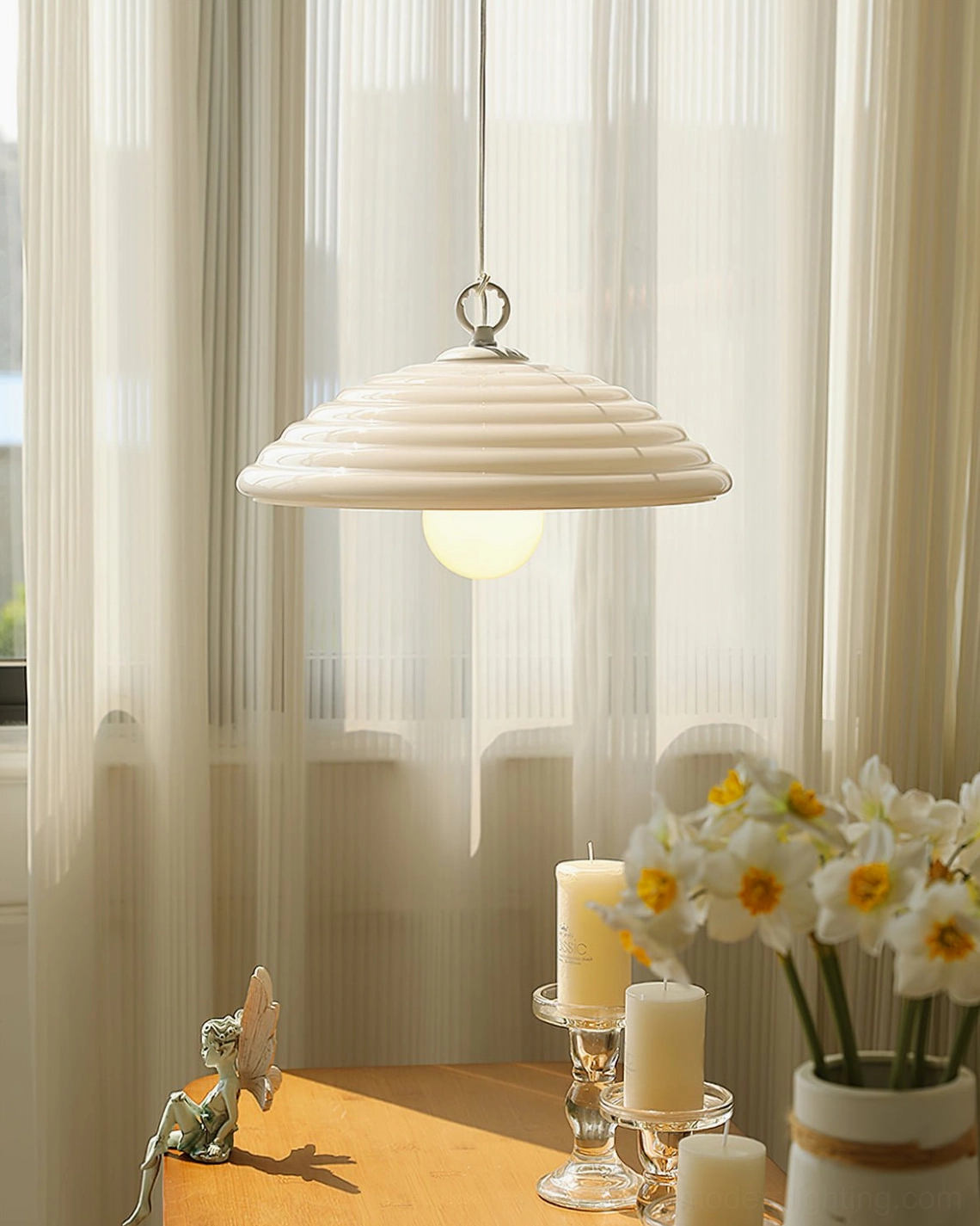 Wave pendant light hanging in dining area with warm cottagecore style decor, floral arrangements and soft illumination