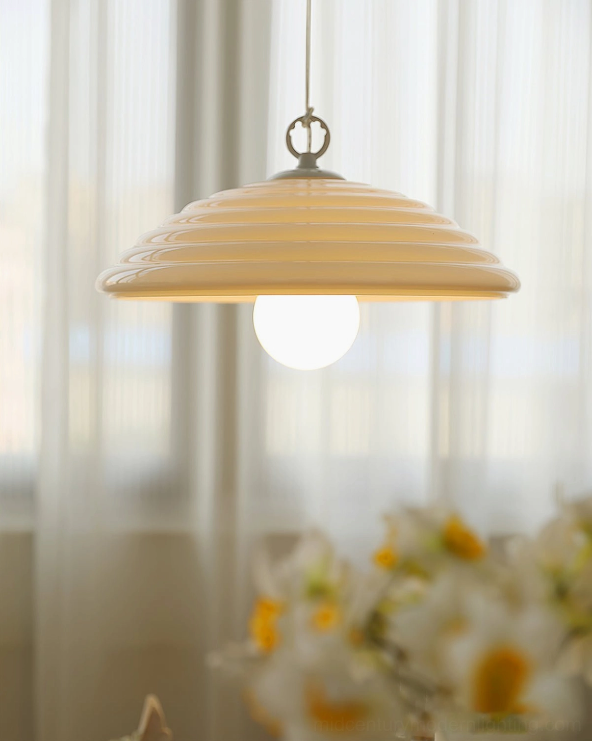 Wave glass pendant lamp side view showing curved ribbed dome suspended in minimalist interior with soft decor accents
