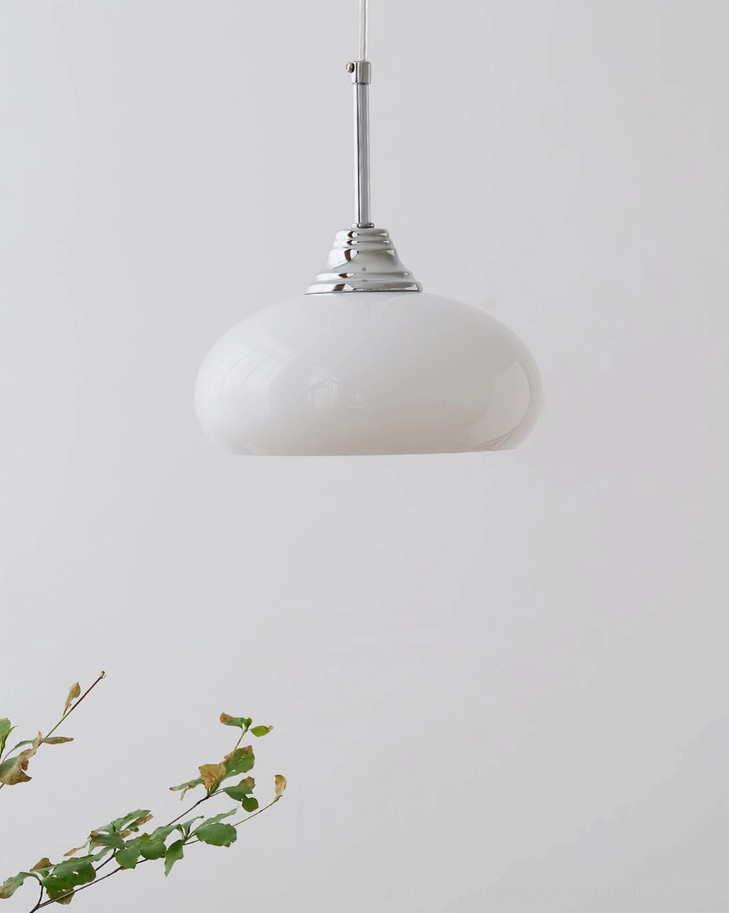 Pure white frosted glass Bell Pendant Light on minimalist backdrop with small green plant
