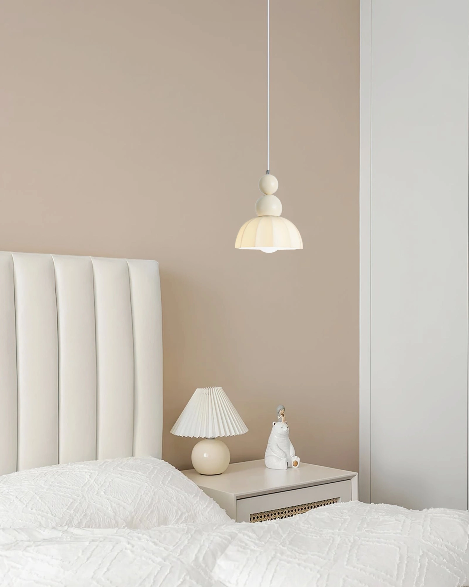 Creamy white gourd bubble pendant lamp above tufted white headboard and nightstand, minimalist bedroom pendant fixture