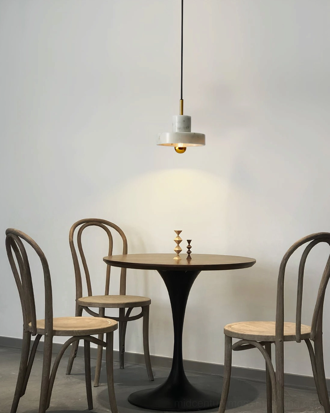 White marble pendant lamp in compact dining corner with tulip table and bentwood chairs